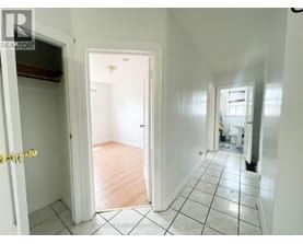 A hallway with a tiled floor and white walls.