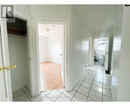 A hallway with a tiled floor and white walls.