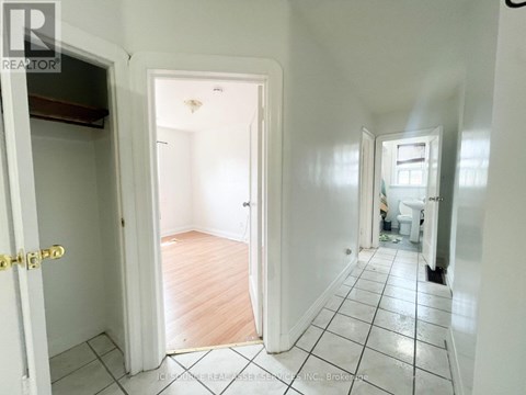 A hallway with a tiled floor and white walls.