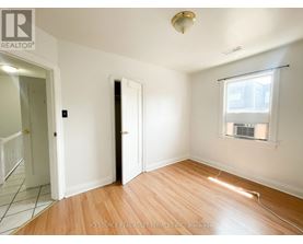 A room with a wooden floor and a window with blinds.