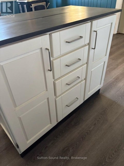 A kitchen with white cabinets and a black countertop.