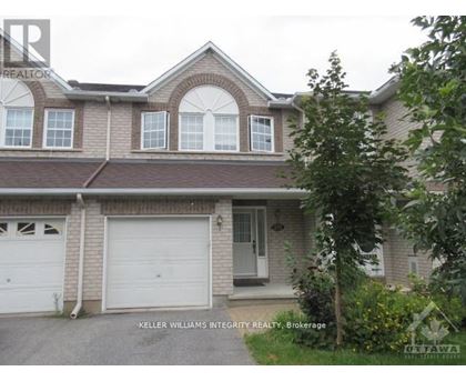 A house with a garage and a tree in front.