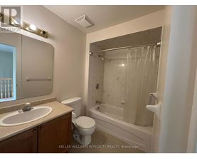 A bathroom with a toilet, sink, and bathtub.