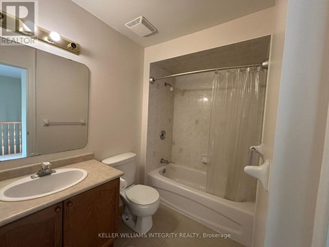 A bathroom with a toilet, sink, and bathtub.