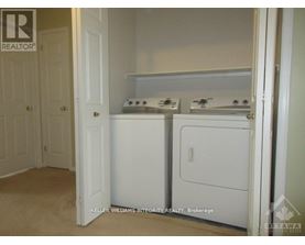 A small white kitchen with a washer and dryer.