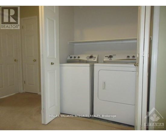 A small white kitchen with a washer and dryer.