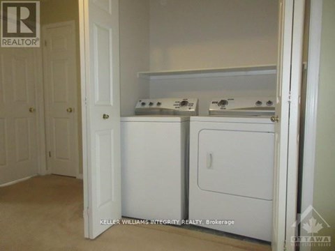 A small white kitchen with a washer and dryer.