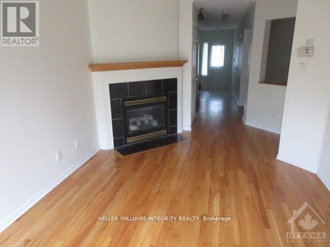 A room with a fireplace and wooden floors.