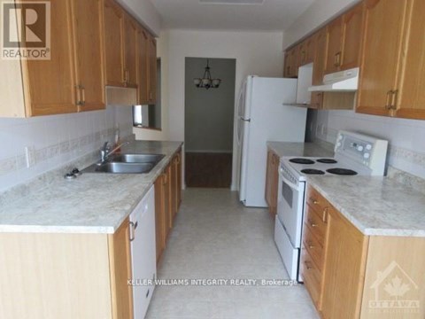 A kitchen with wooden cabinets and a white refrigerator.