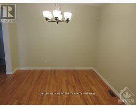 A room with a chandelier and a wooden floor.