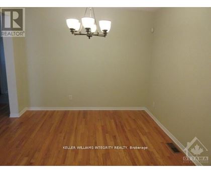 A room with a chandelier and a wooden floor.