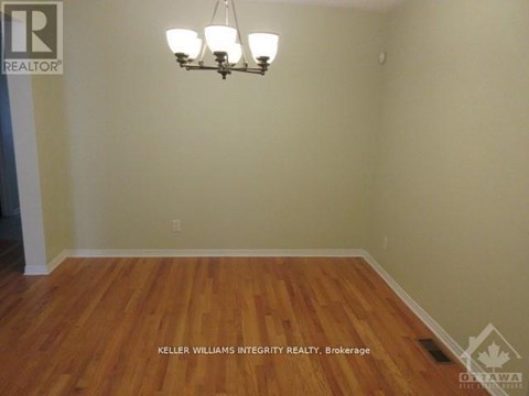 A room with a chandelier and a wooden floor.