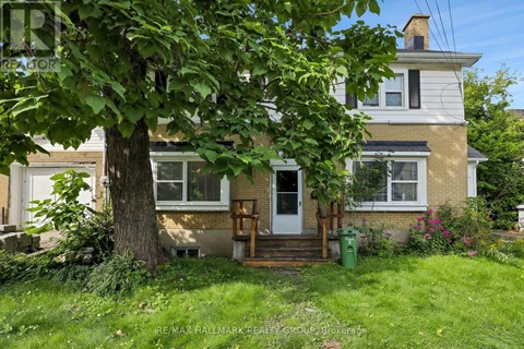 A tree in front of a house with a white door.