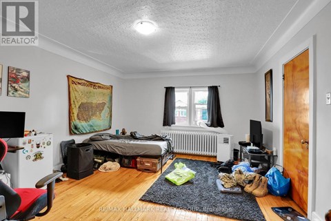 A bedroom with a bed, a chair, and a dungeons and dragons poster on the wall.