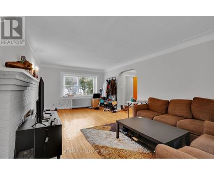 A living room with a brown couch and a black television.