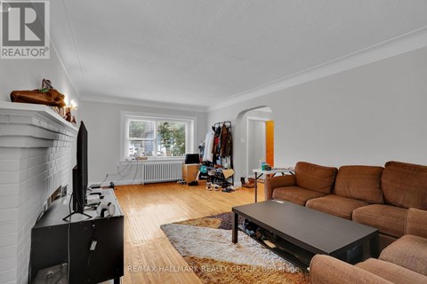 A living room with a brown couch and a black television.