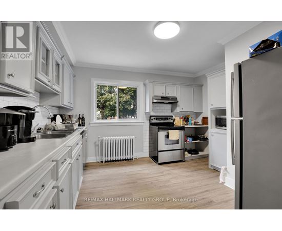 A kitchen with white cabinets and a refrigerator.