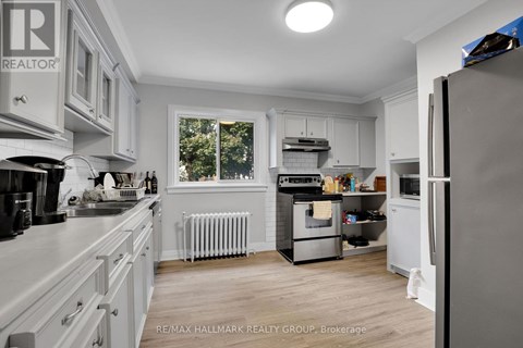 A kitchen with white cabinets and a refrigerator.