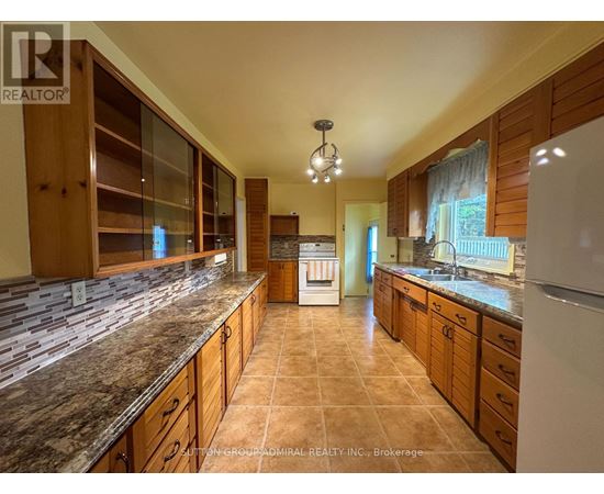 A kitchen with granite countertops and wooden cabinets.