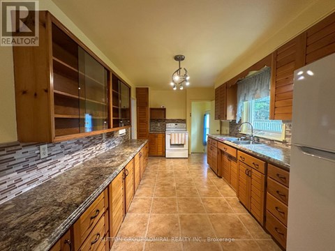 A kitchen with granite countertops and wooden cabinets.