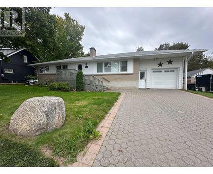 A house with a driveway and a large rock in the front yard.