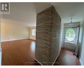 A room with a brick pillar and a door leading outside.