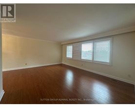 A room with wooden flooring and white walls.