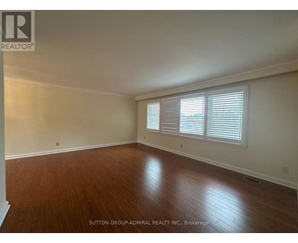A room with wooden flooring and white walls.
