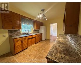 A kitchen with wooden cabinets and a granite countertop.