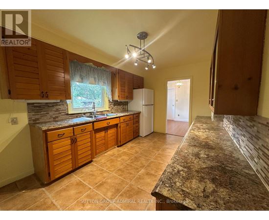 A kitchen with wooden cabinets and a granite countertop.