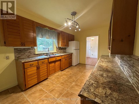 A kitchen with wooden cabinets and a granite countertop.