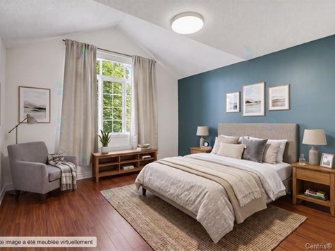 A bedroom with a bed, nightstand, and chair.