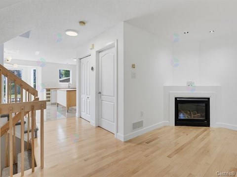 A living room with a fireplace and a staircase.