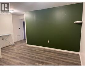 A room with a green wall and wooden flooring.