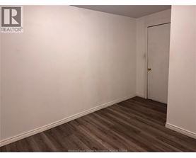 A room with a wooden floor and a white door.