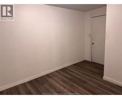 A room with a wooden floor and a white door.