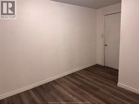 A room with a wooden floor and a white door.