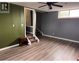 A room with a green wall and a wooden floor.