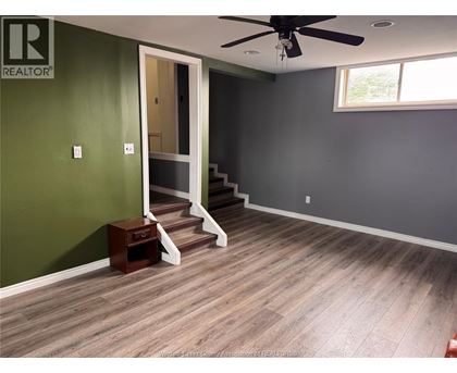 A room with a green wall and a wooden floor.