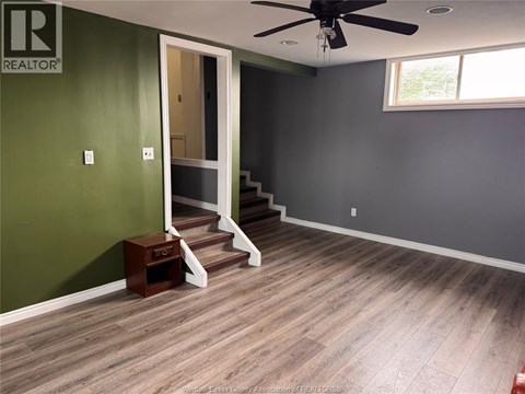 A room with a green wall and a wooden floor.