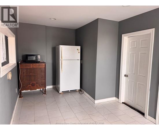 A kitchen with a white fridge and a wooden cabinet.