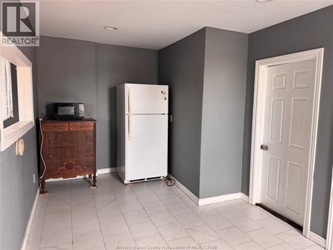 A kitchen with a white fridge and a wooden cabinet.