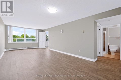 A spacious room with a door leading to another room.