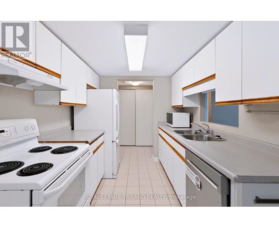 A white stove top oven with a white refrigerator in a kitchen.