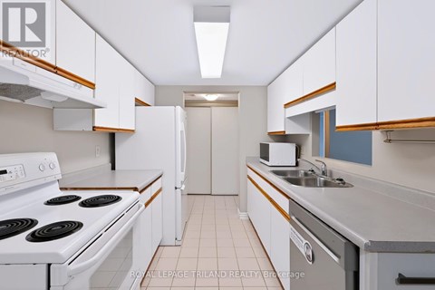 A white stove top oven with a white refrigerator in a kitchen.