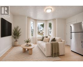 A living room with a couch, a coffee table, and a television.