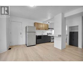 A well-lit, modern kitchen with wooden cabinets and stainless steel appliances.