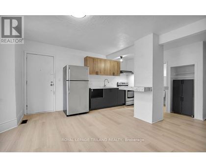 A well-lit, modern kitchen with wooden cabinets and stainless steel appliances.