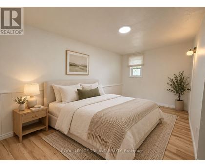 A bedroom with a bed, nightstand, and lamp.