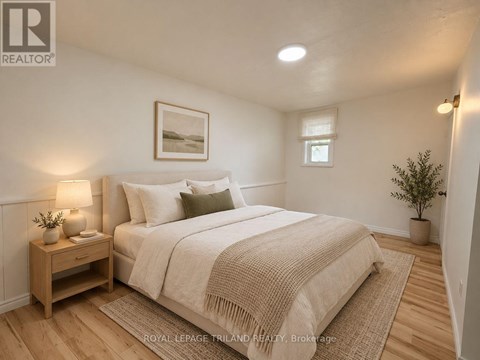 A bedroom with a bed, nightstand, and lamp.